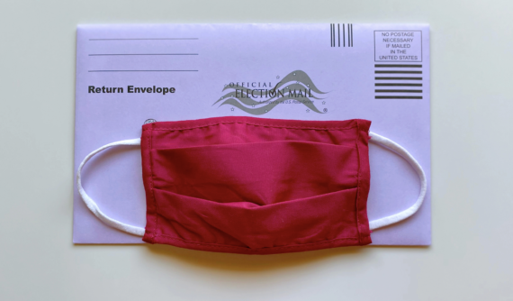 Face mask on top of a vote by mail envelope
