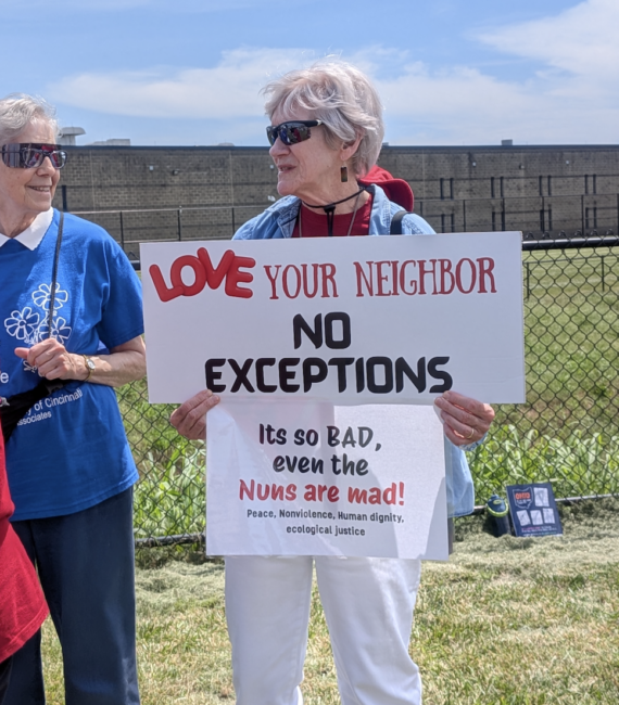 A white woman in sunglasses carries a sign that says "Love your neighbor, no exceptions" and "its so bad even the nuns are mad"